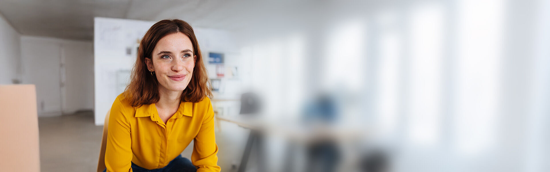 eine Frau in einem gelben Hemd und schwarze Hose steht in einem Büro