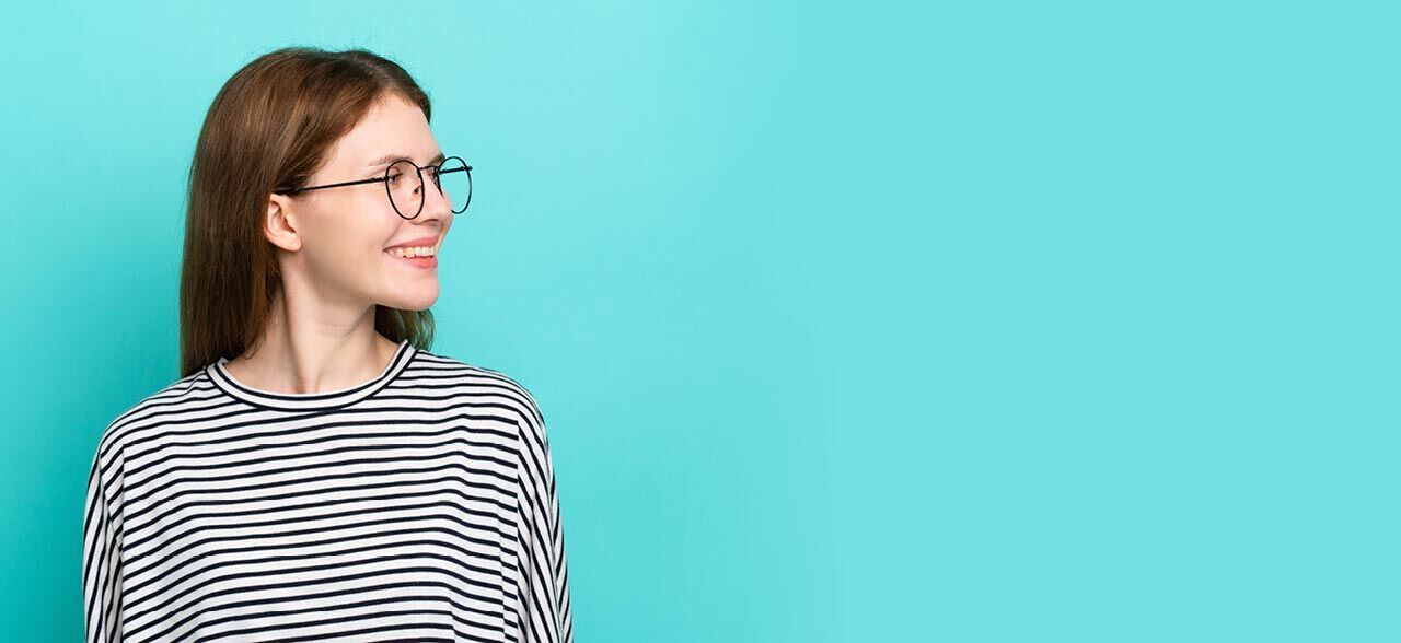 eine Frau mit Brille auf ihrem Gesicht vor blauem Hintergrund